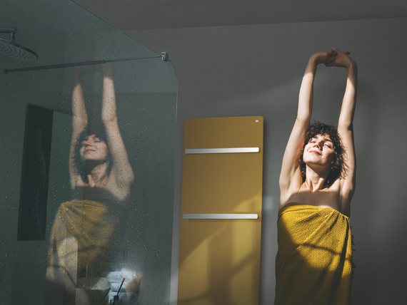 Beautiful young woman doing morning routine at home, sunny day. A woman in a towel does a warm-up after a shower.
